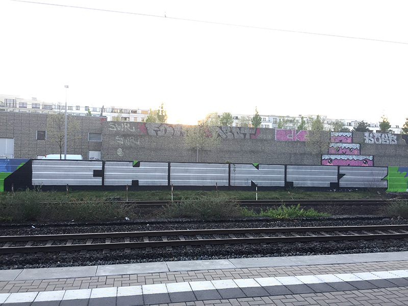 Blockbusterstyle in chrom-schwarz an einer Schallschutzmauer